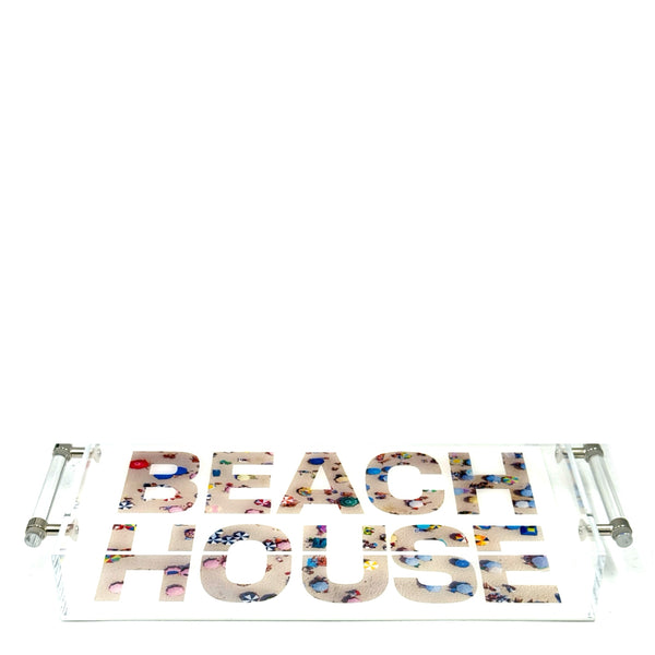 Top view of a clear acrylic tray with Beach House lettering filled with a beach-scene print.