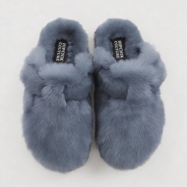 Top view of denim blue fur clogs showing their closed toes, plush lining and adjustable straps.