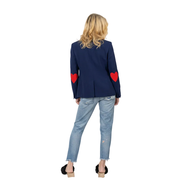 Person wearing a navy blazer with red heart designs on sleeves against a white background