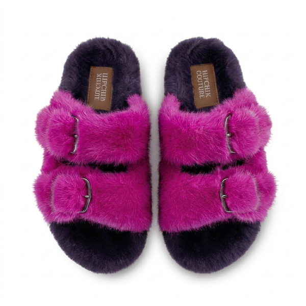 Pair of pink fuzzy slippers with buckles on a white background