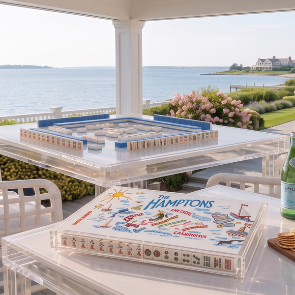 Hamptons-themed acrylic Mahjong case displayed on a table beside a game setup overlooking the water.