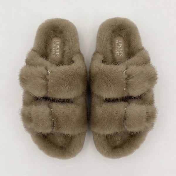 Top view of natural taupe fur slide sandals showing their plush lining and two buckled straps.