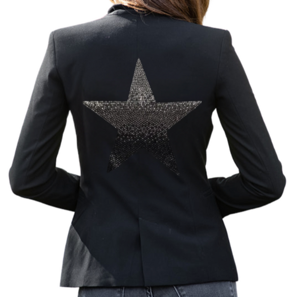 Woman wearing a black blazer with a large ombre rhinestone star on the back.