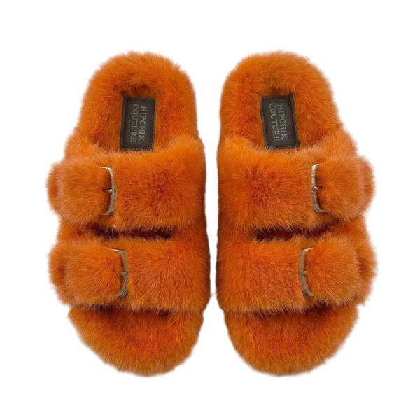 Top view of orange fur slide sandals showing their plush lining and two buckled straps.