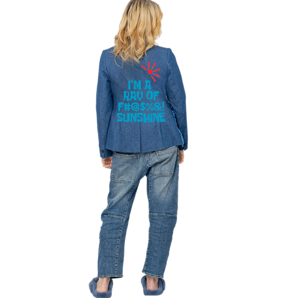 Back view of a woman wearing a blue denim blazer with turquoise sunshine slogan lettering and a red sun, paired with blue jeans and blue fur slides.