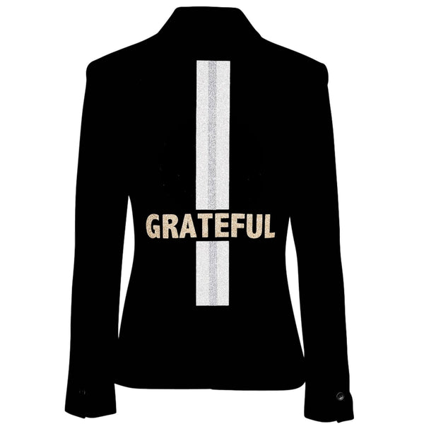 Back view of a black blazer with gold GRATEFUL lettering across a vertical silver stripe.