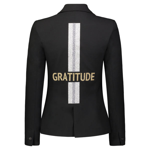 Back view of a black blazer with gold GRATITUDE lettering across a vertical silver stripe.